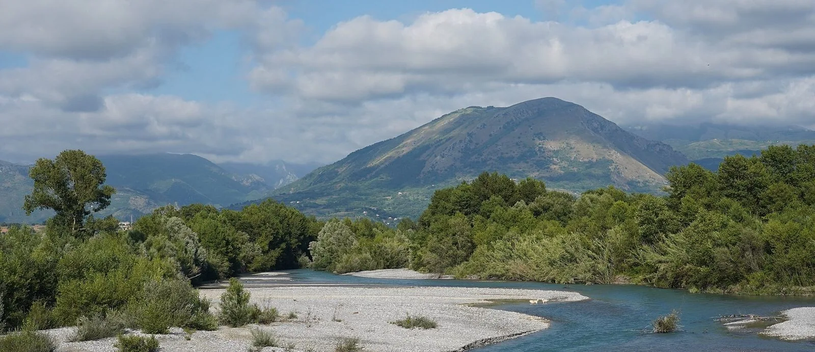 Il fiume Lao tra greti di ciottoli e vegetazione, con le montagne del Pollino sullo sfondo